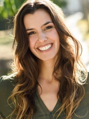 Beautiful woman smiling confidently while walking in an urban park setting