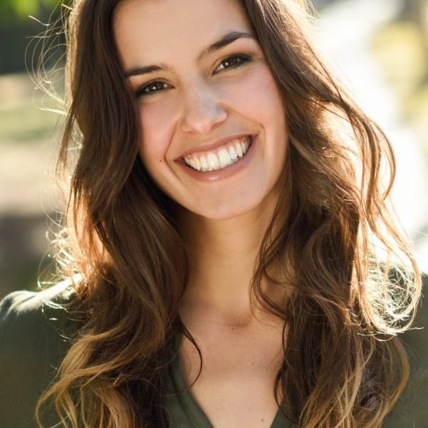 Beautiful woman smiling confidently while walking in an urban park setting