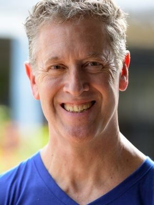 Happy mature man smiling warmly outdoors in an urban street setting