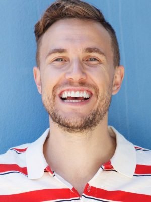 Happy young man in a striped shirt laughing joyfully